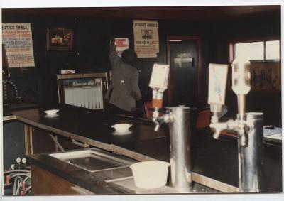 Charlie Graves, owner, installing a sign in the Uptown Club.