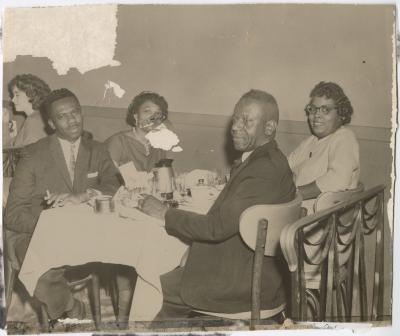 Black and white photo of a group having a meal together 
