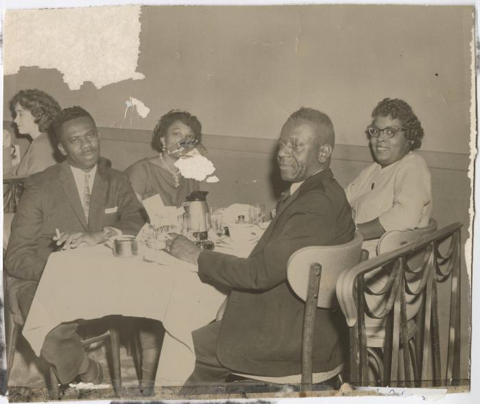 Black and white photo of a group having a meal together 