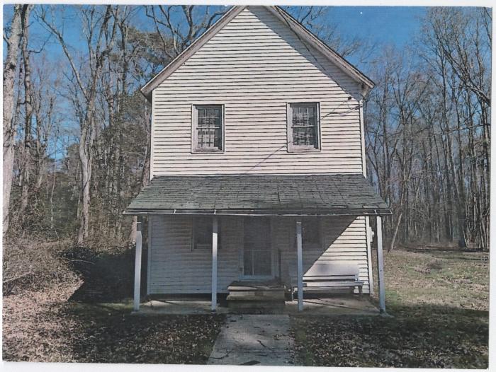 The front of a two-story white house.