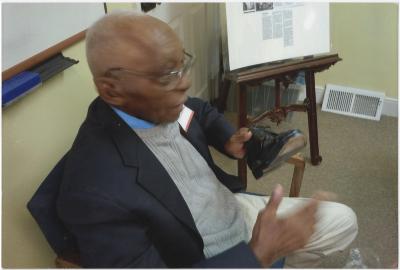 Man sitting in a chair in front of a whiteboard.