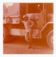 Sergeant Roy D. Thomas, Jr. leaning on a large vehicle