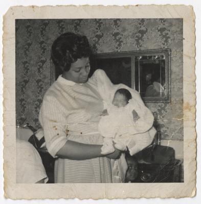 A Black and White Photo of a Woman Holding an Infant