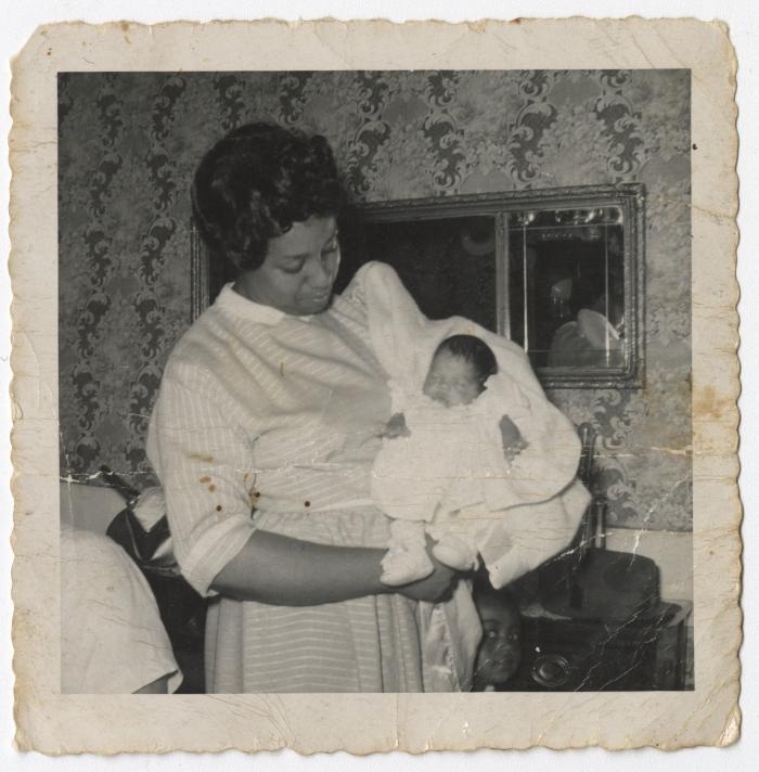 A Black and White Photo of a Woman Holding an Infant