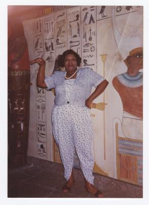 Valerie Anderson posing in front of Egyptian mural