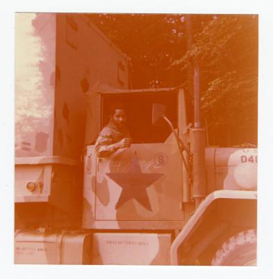 A man sitting in a large military vehicle