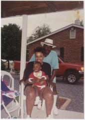 A Couple with an Infant Taking a Photo on a Porch