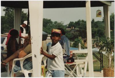 Photo of a Young Boy Playing Outside During an Outdoor Gathering