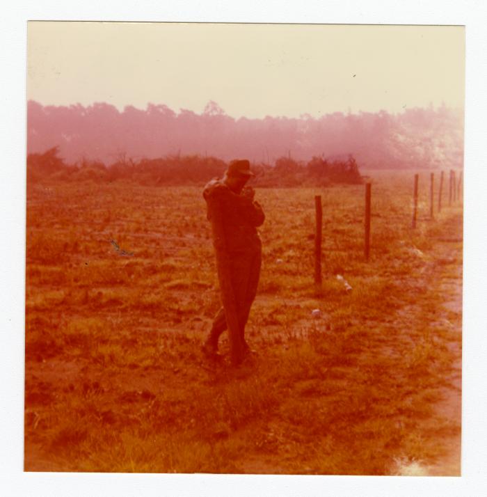Eleanor Rochelle Ringgold leaning on a fence post
